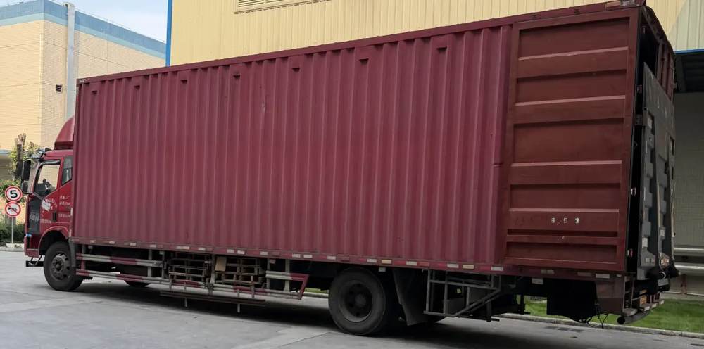 Un camión trasladando un contenedor de mercancías al puerto de exportación